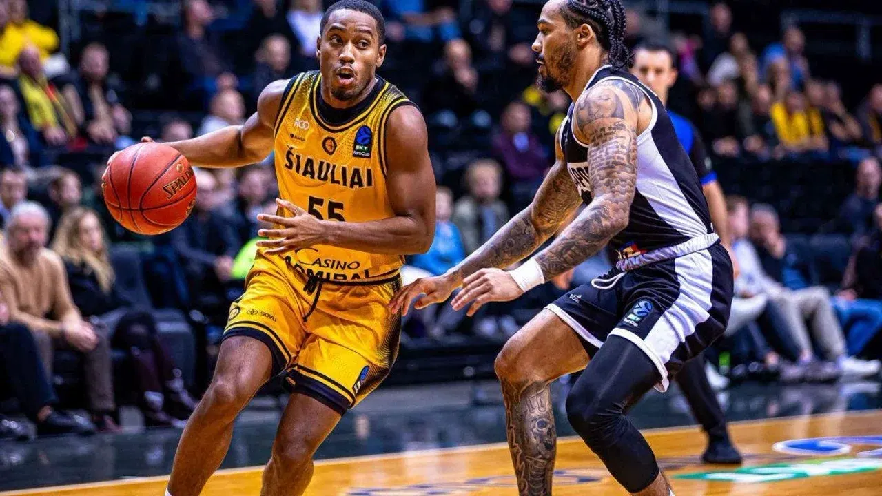 Jucător de la BC Siauliai cu mingea, urmărit de un baschetbalist U-BT Cluj-Napoca, într-un meci din EuroCup