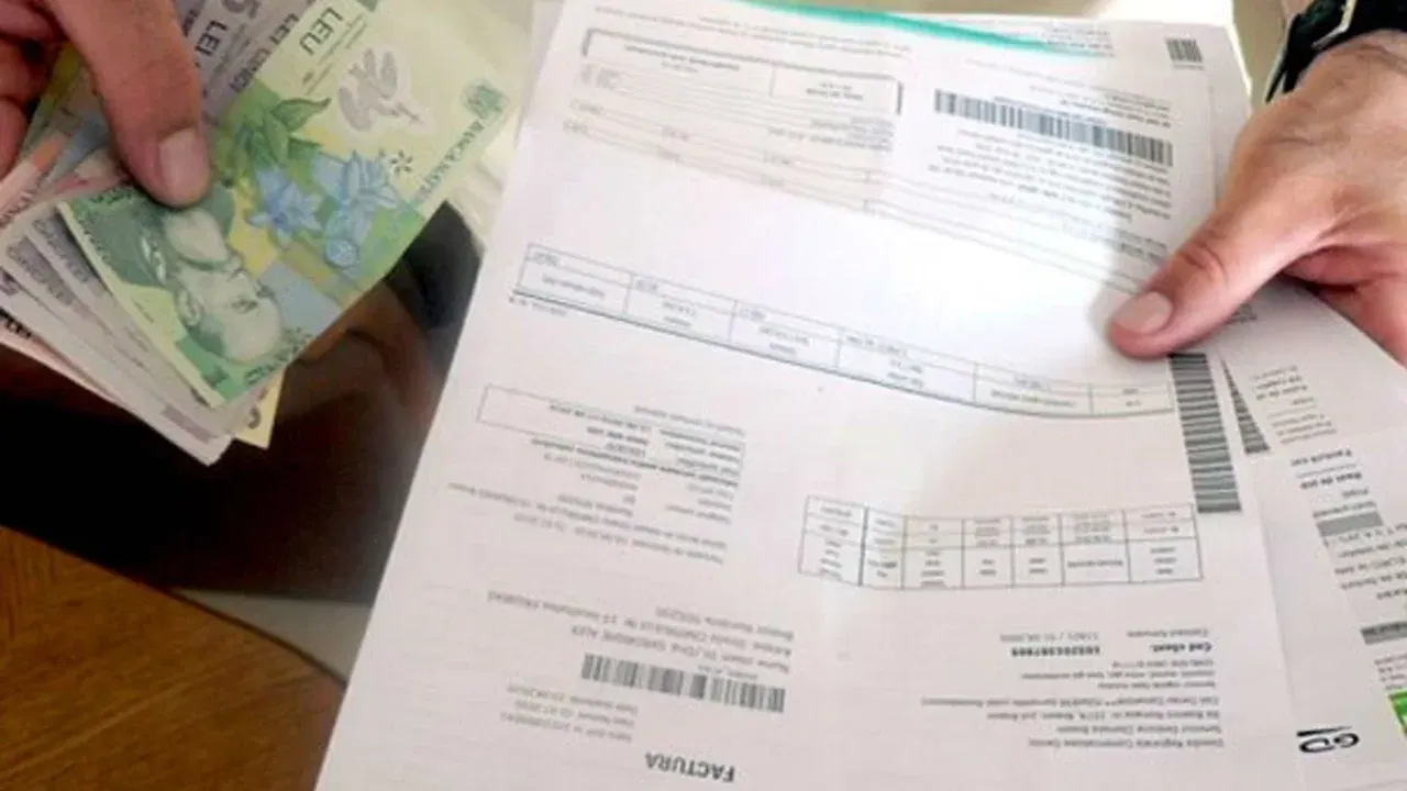 Facturi de utilități și bancnote ținute în mâini