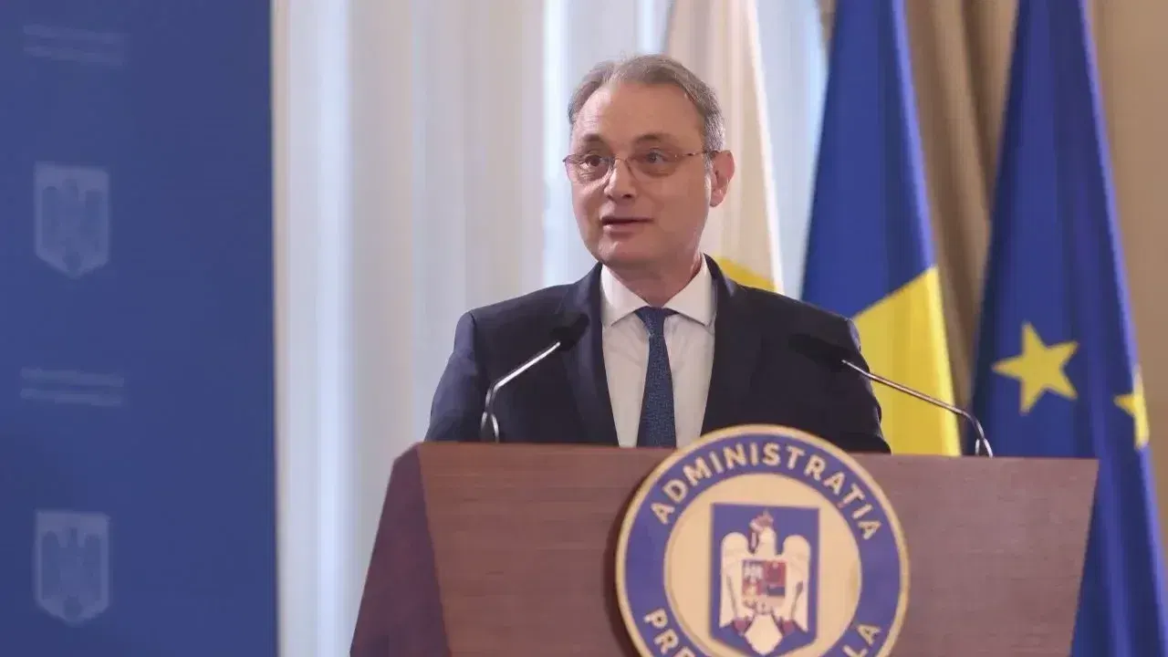 Luca Niculescu vorbește la un pupitru oficial, în fața steagurilor României și Uniunii Europene