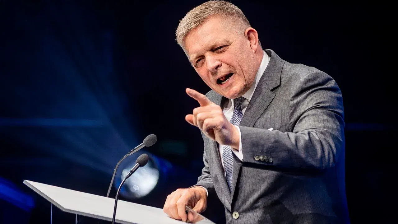 Robert Fico vorbește la un pupitru și arată cu degetul în timpul unui discurs