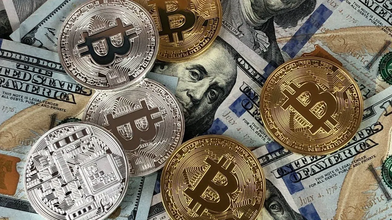 Monede Bitcoin și bancnote americane, imagine ilustrativă pentru fraude online cu investiții