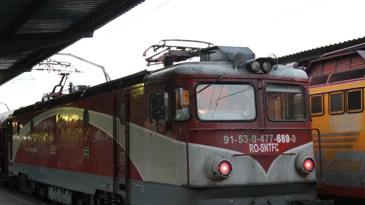Locomotivă electrică și tren de călători într-o gară din România, imagine ilustrativă