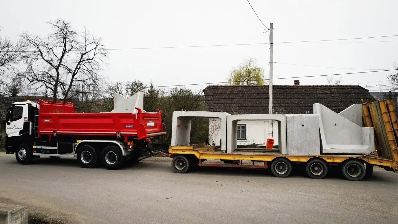 Camion Nello Construct cu remorcă joasă care transportă prefabricate din beton