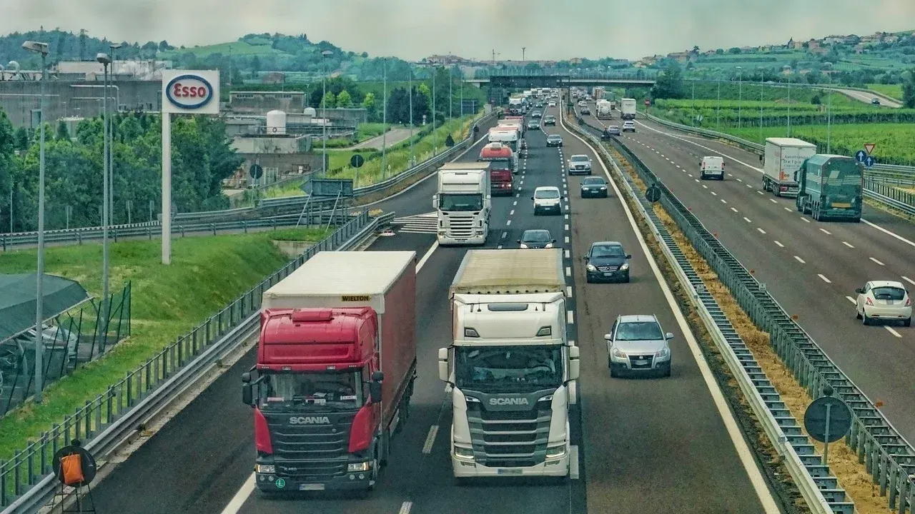 Camioane de marfă și autoturisme care circulă pe o autostradă