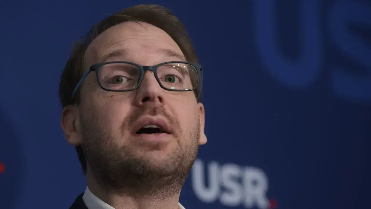 Dominic Fritz vorbind în fața unui panou cu sigla USR